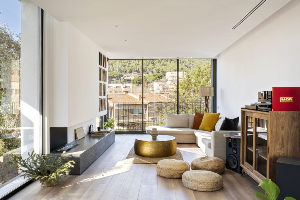 Salón luminoso con grandes ventanales orientados al sur que aprovechan la luz natural y las vistas al paisaje urbano.