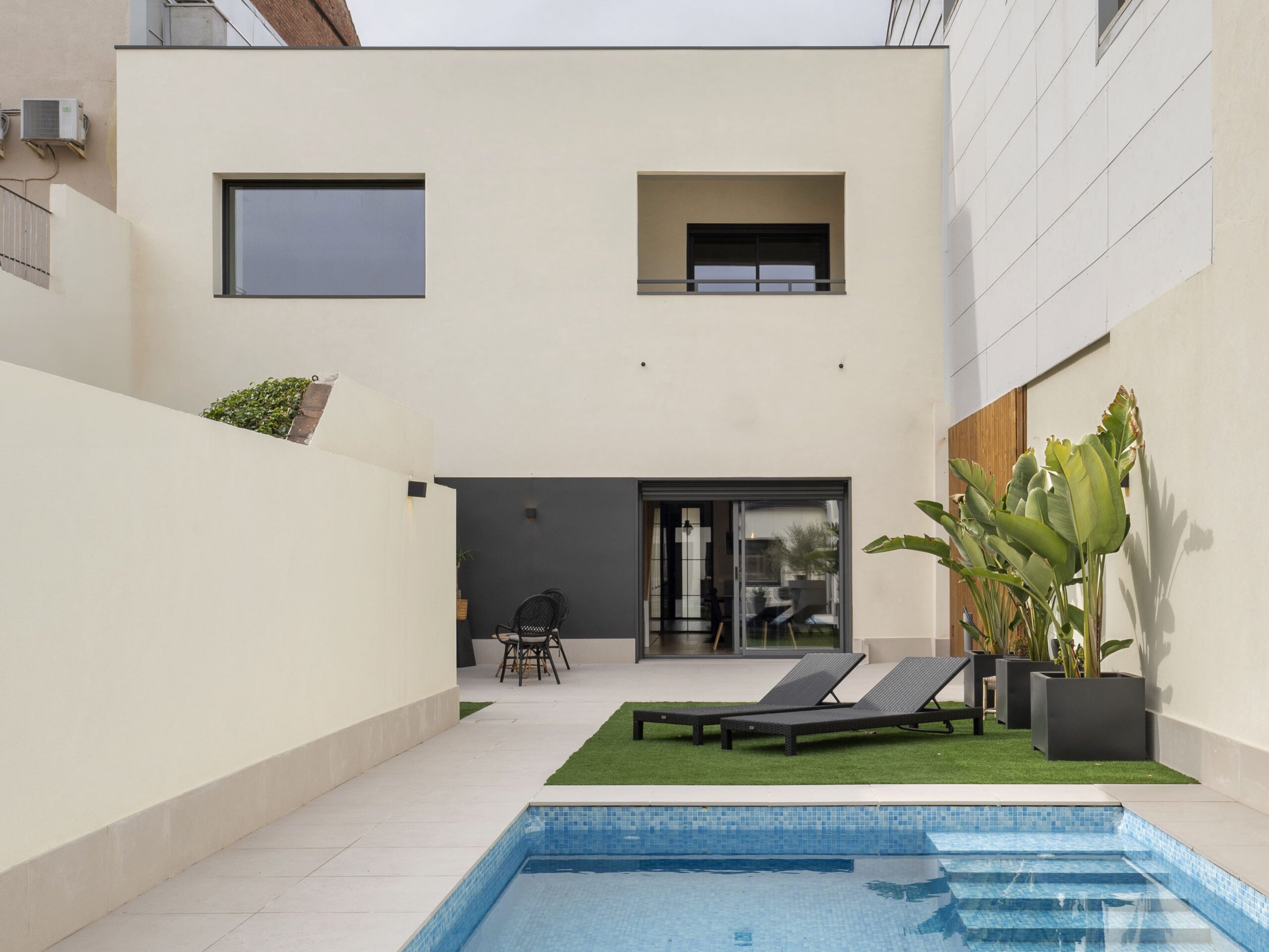 Resultado final de una reforma integral con piscina y diseño contemporáneo, ejemplo de arquitectura luminosa y eficiente tras la renovación.