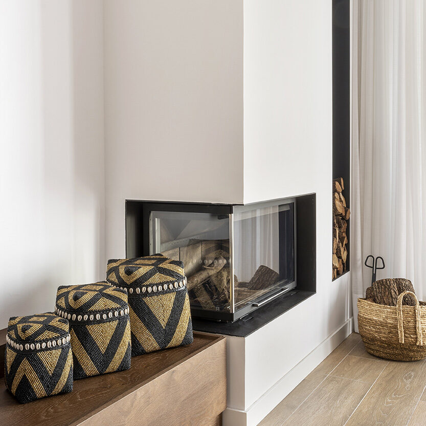 Chimenea integrada en un salón de diseño que contribuye a la eficiencia energética mediante una distribución térmica óptima y materiales cálidos.