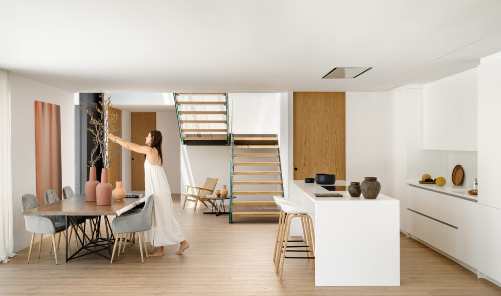 Suelo de madera natural en un espacio de cocina y comedor, ejemplo de arquitectura luminosa y diseño de interiores cálido.