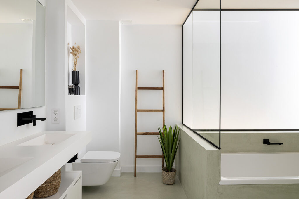 Baño moderno y funcional diseñado para el confort en el día a día, con lavabo integrado, bañera y circulación fluida.