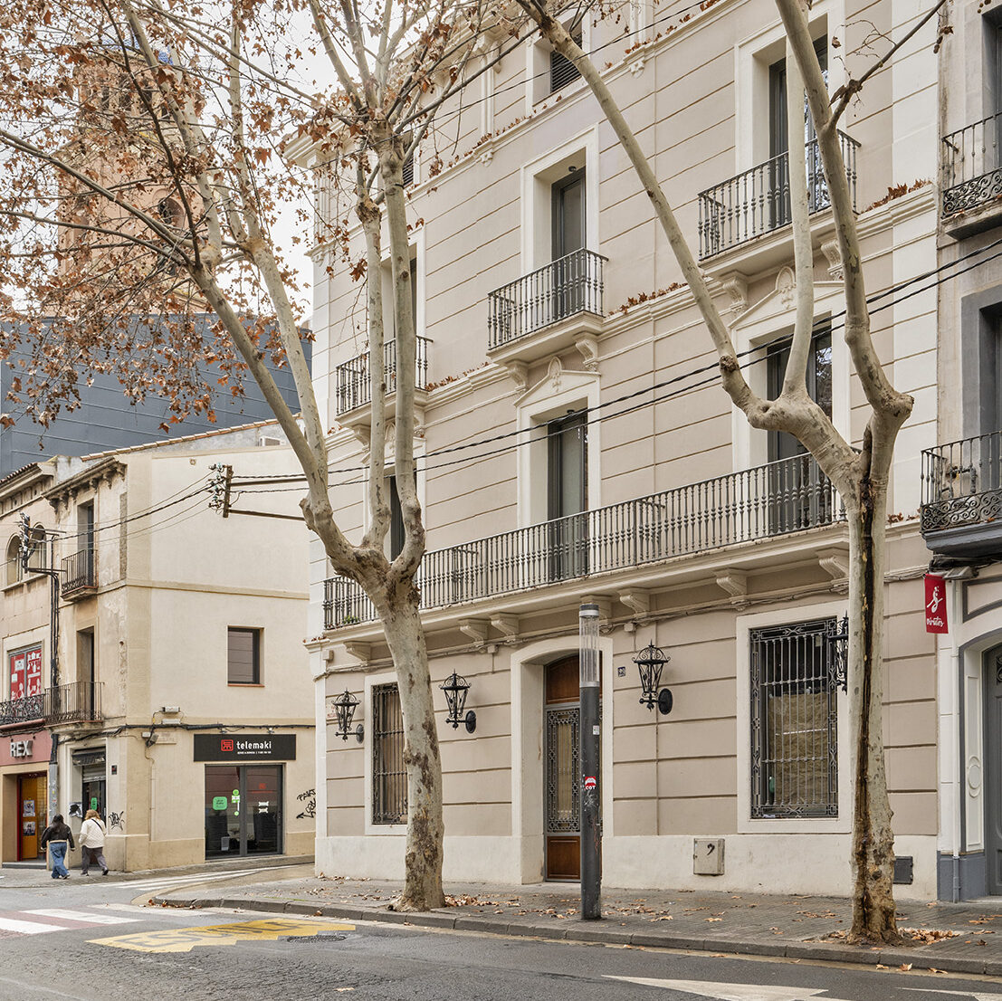 Fachada de edificio residencial integrada en el entorno urbano, con equilibrio entre composición arquitectónica, luz natural y relación con la calle.