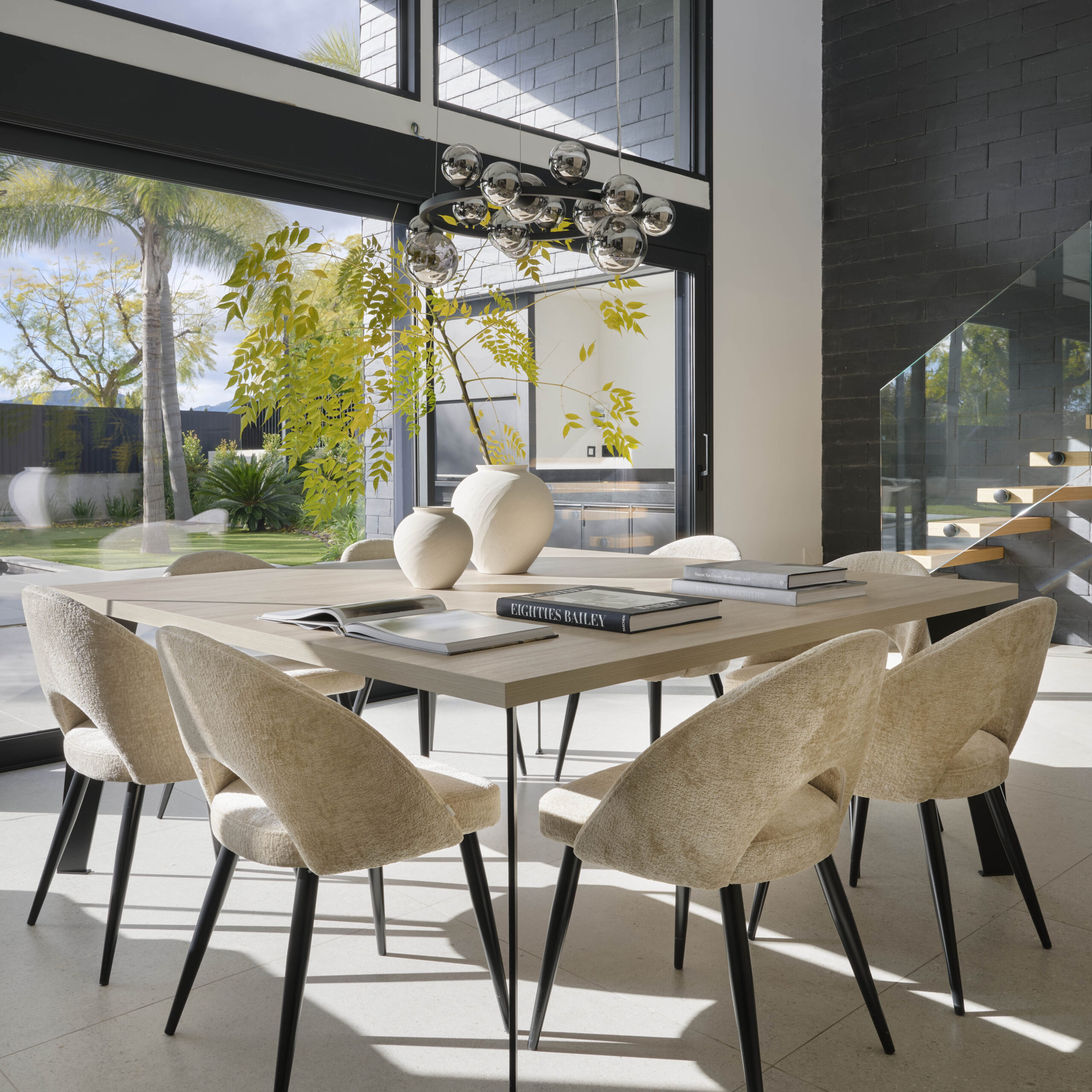 Diseño de interiores en comedor de vivienda con grandes ventanales.