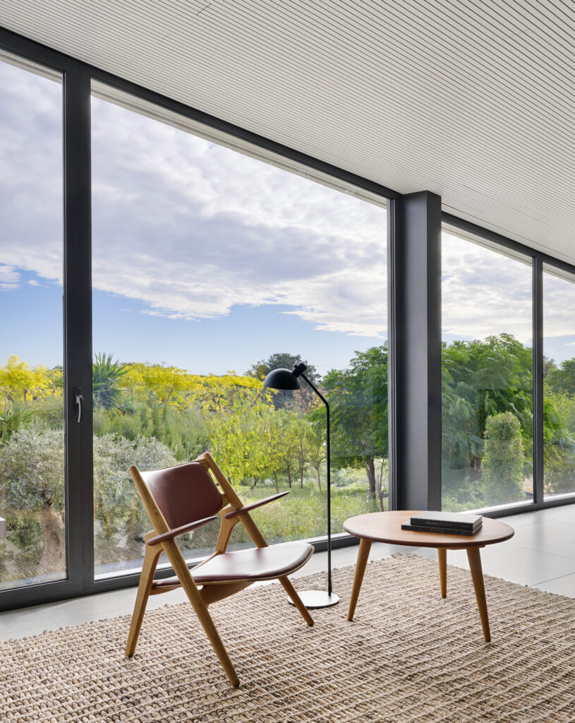 Interior de vivienda con grandes ventanales y diseño interior minimalista.