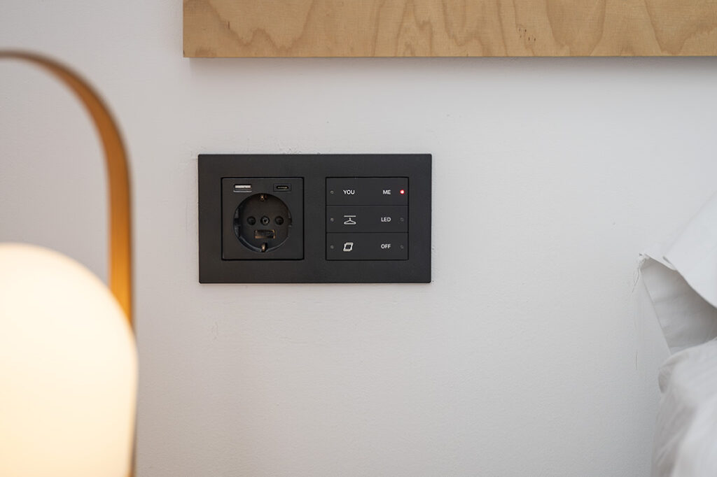 Interruptor domótico integrado en la pared de una vivienda, ejemplo de domótica aplicada a la arquitectura para mejorar el confort y el control de la iluminación.