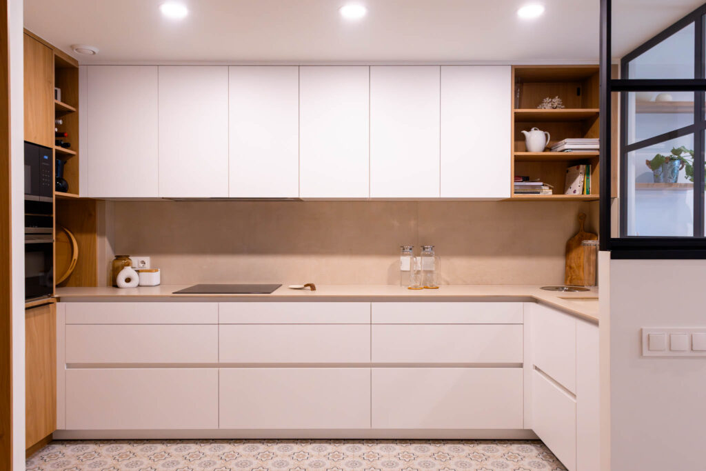 Cocina en L con distribución equilibrada entre zona de trabajo y almacenamiento en un espacio luminoso.