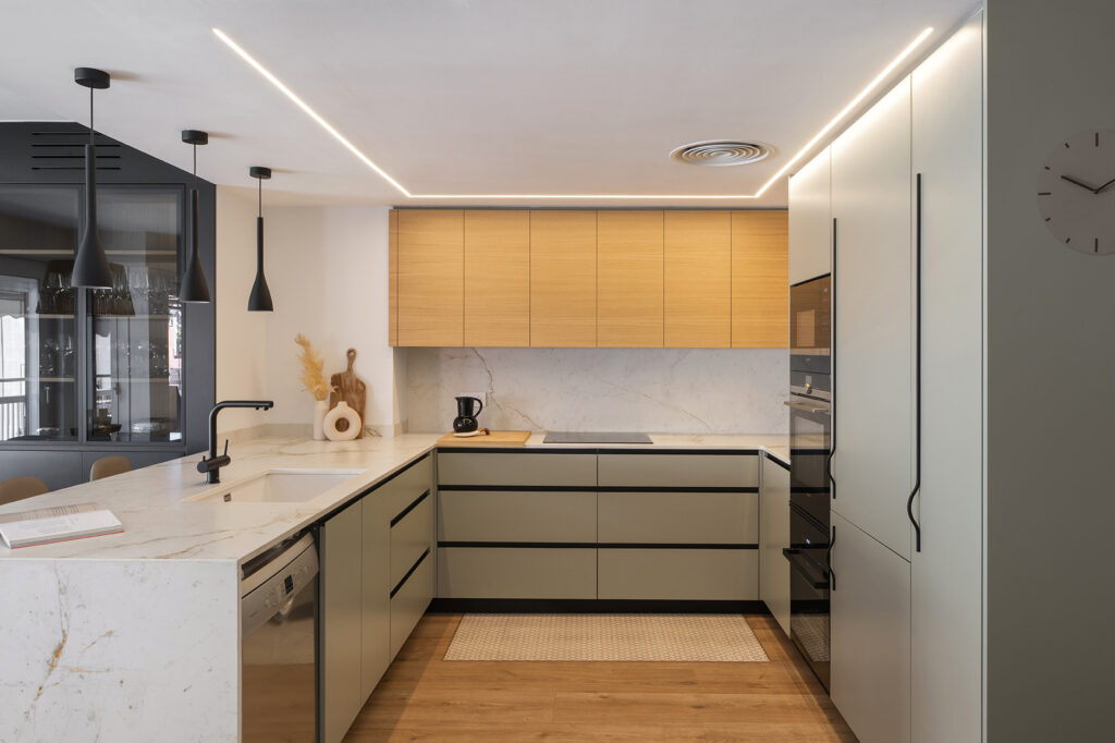 Cocina en U con distribución envolvente que maximiza el espacio de trabajo y el almacenamiento.