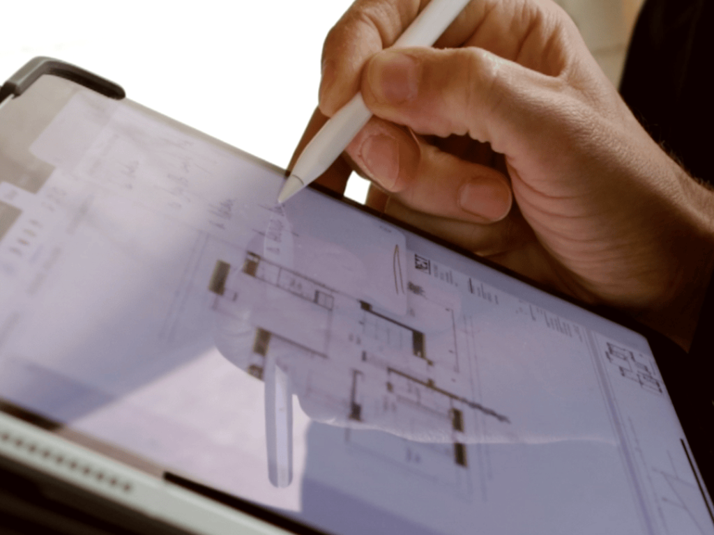 Tecnología digital para diseñar planos en una tablet, ejemplo de innovación y eficiencia en arquitectura moderna.|Se utiliza tecnología de realidad virtual para visualizar un proyecto de arquitectura en una pantalla grande dentro de un estudio en Sabadell.||||Equipo de arquitectura utilizando tecnología digital para diseñar espacios en 3D, ejemplo de innovación y eficiencia en proyectos arquitectónicos.